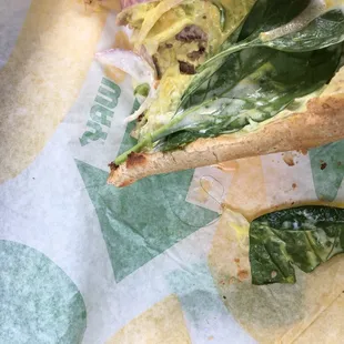 a half eaten sandwich on a piece of paper