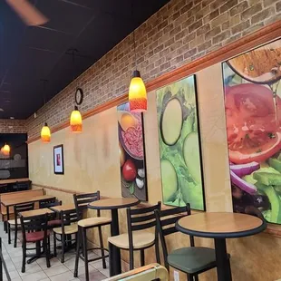 the interior of a restaurant with tables and chairs