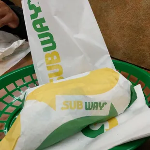 a subway sandwich in a basket on a table