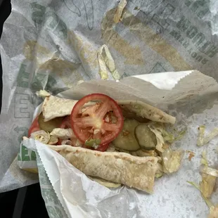 a half eaten sandwich in a wrapper