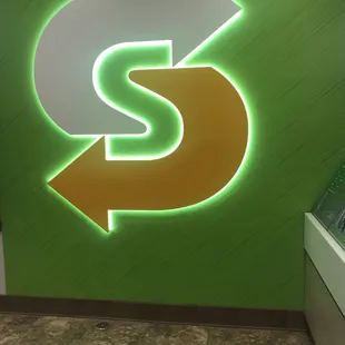 a subway sign with a dollar sign in the background