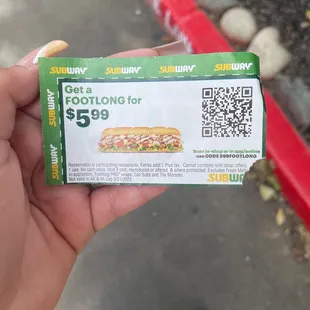 a person holding a ticket for a sub sandwich