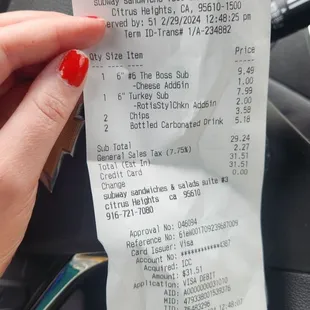 a woman's hand holding a receipt