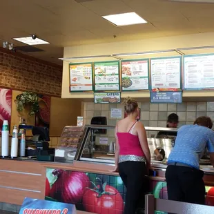 a woman and a man standing at a counter