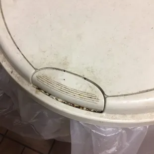 a dirty toilet seat with a drain