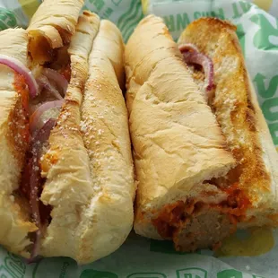 two sub sandwiches on a paper wrapper