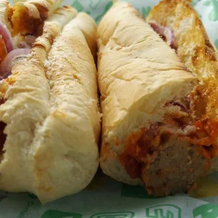two meatball subs on a paper wrapper