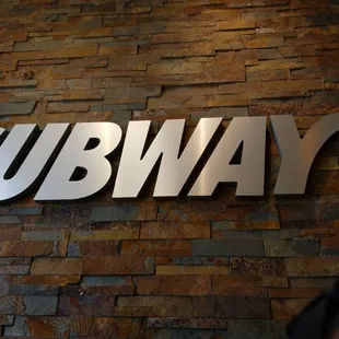 subway subway sign on a brick wall