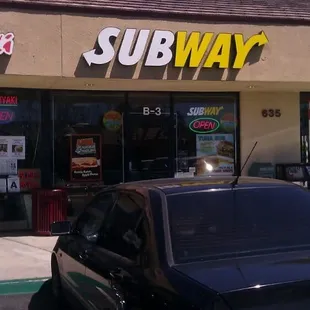 a car parked in front of a subway restaurant