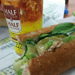 a half eaten sandwich and a drink