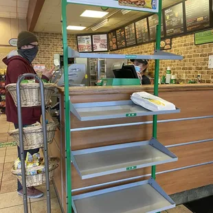a man wearing a face mask standing in front of a counter