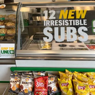 a display of subs and baked goods