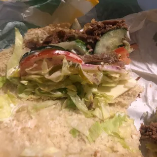 a sandwich with lettuce, tomatoes, and meat