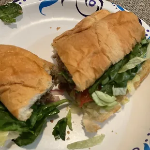 a sandwich on a plate with lettuce and tomato