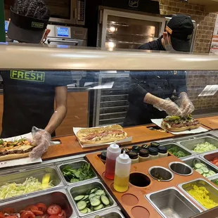 two people preparing food in a subway