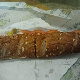 a sandwich on a wrapper with tomatoes