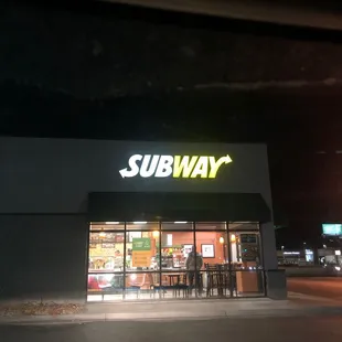 the entrance of a subway restaurant at night