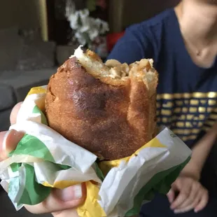 a person holding a sandwich in their hand