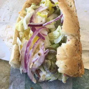 a closeup of a sandwich with onions and lettuce
