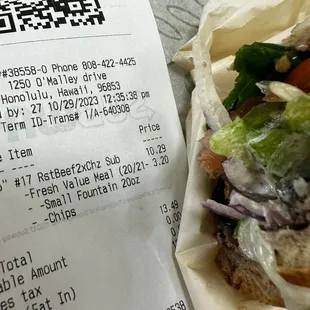 a receipt and a sandwich on a table