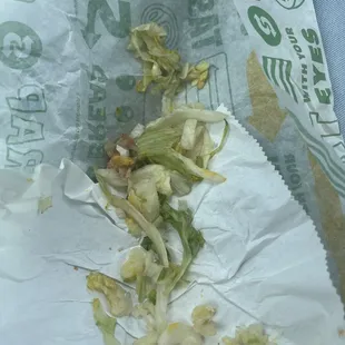 a half eaten sandwich in a wrapper