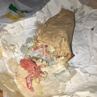 a half eaten sandwich on a piece of paper