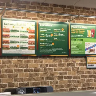 menus on a brick wall in a subway