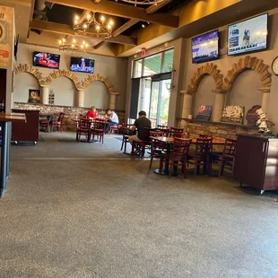 the inside of a restaurant with tables and televisions
