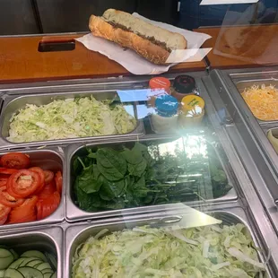 a hot dog, salads, and vegetables