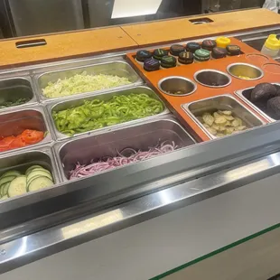 a variety of salads in a display case