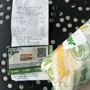 a receipt and a sandwich on a table