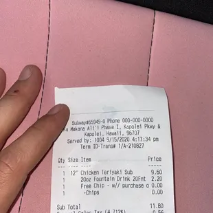 a person's hand holding a receipt