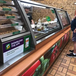 a man standing in front of a deli counter