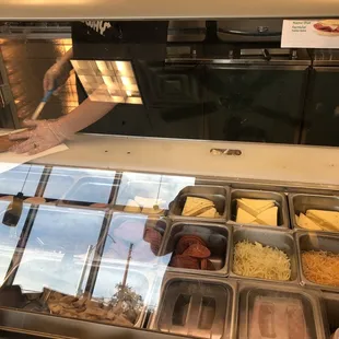 a person reaching for food in a display case