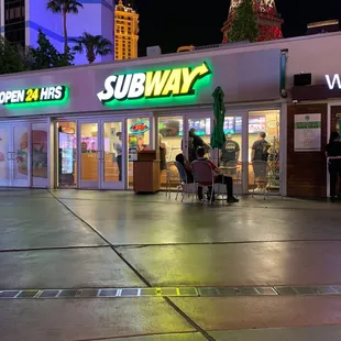 the entrance to a subway restaurant at night