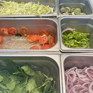 a variety of vegetables being prepared in trays