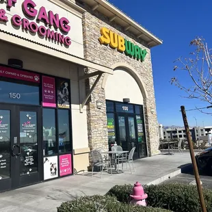 outside of a restaurant with a pink fire hydrant