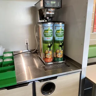 a coffee machine with two cans of coffee on top of it