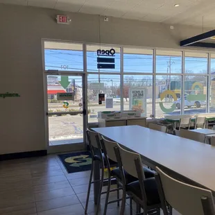 a long table with chairs in front of a large window