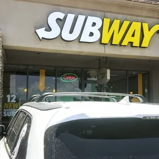 a car parked in front of a subway restaurant
