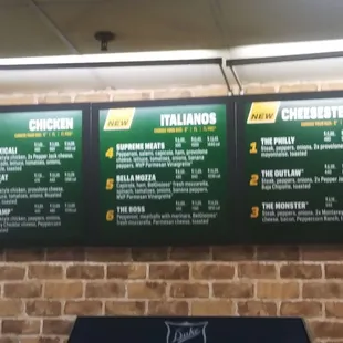 menus on a brick wall in a subway