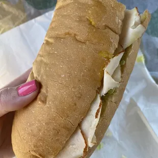 a person holding a sandwich in their hand