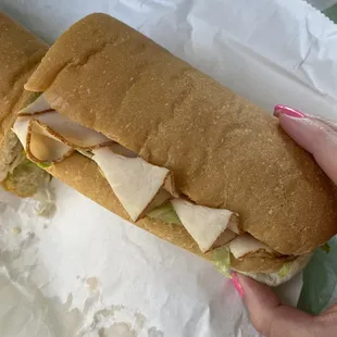 a person holding a sandwich in their hand