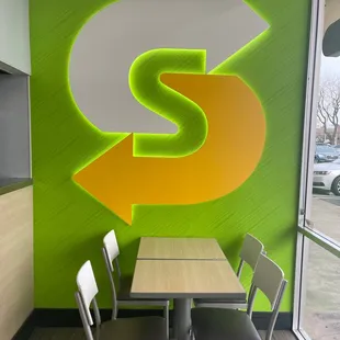 a table and chairs in front of a wall with a dollar sign painted on it