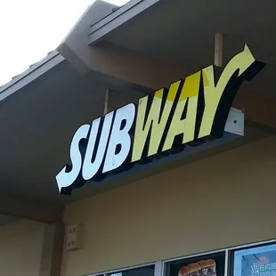 a subway sign on the side of a building