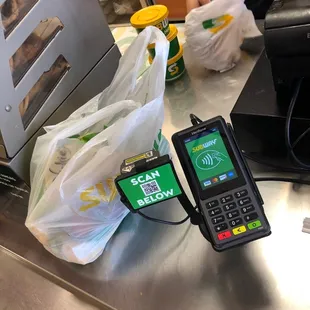 two bags of food and a pos terminal