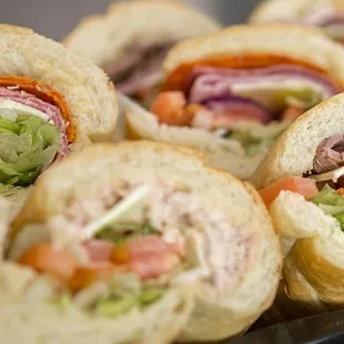 a tray of sandwiches with lettuce, tomato, and meat