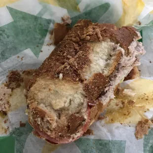 a half eaten sandwich on wax paper