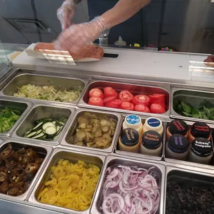 a man preparing a salad in a deli