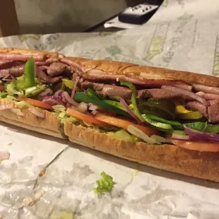 a sub sandwich with meat and vegetables